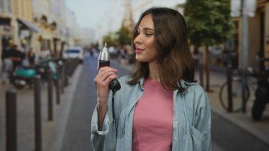 Latin kökenli genç bir kadın elinde matkap ile şehir sokaklarında dikiliyor. Açık hava sahnesini gündelik tarzda ve kendinden emin bir ifadeyle gözler önüne seriyor..