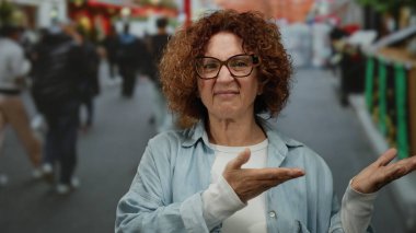 Bulanık yayalarla çevrili, hareketli bir şehir caddesinde, dinamik enerjili, güneşli bir İspanyol ortamında canlı bir şehir atmosferini yakalayan bir kadın..