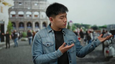 Genç Çinli adam, şehir caddesinde Roma Kolezyumu 'nun önünde ellerini uzatarak modern modayla tarihi mimariyi ve canlı şehir yaşamını harmanlıyor..
