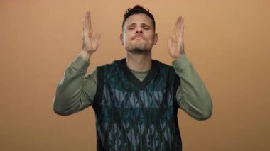 Genç İspanyol bir adam, elleri ile bir çerçeve hareketi yapıyor izole bir kahverengi duvar arkaplan yaratıcı ifade ileten