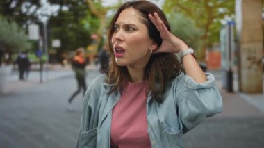 Şehir sokaklarında yaşayan İspanyol bir kadın, şehir hayatı ve canlı kültürle çevrelenmiş, açık havada samimi bir anı anlamlı bir bağlılıkla yakalamak için dikkatle dinlemeyi işaret ediyor..