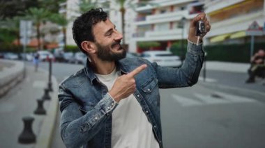 Sakallı İspanyol bir adam canlı bir sokak sahnesinde arabanın anahtarlarını tutuyor, şehir yaşamını ve modern ulaşımı gözler önüne seriyor..