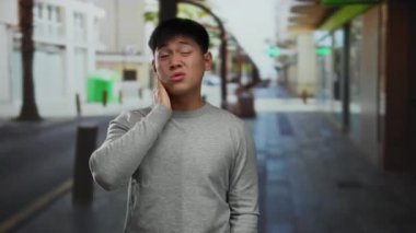 Gündüz vakti şehrin arka planında dikilirken rahatsız edici ya da kafa karıştırıcı davranışlar sergileyen genç bir adam..