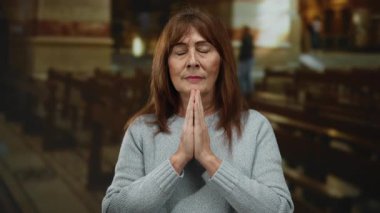 İspanyol kadın kilisede huzur içinde dua ediyor. Gözleri kapalı ve elleri sımsıkı kapalı. İç gözlem ve ruhaniliğin vücut bulmuş hali..