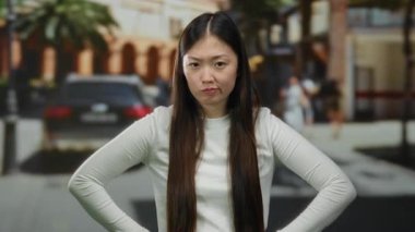 Şehir sokaklarında kendine güvenen bir kadın, şehir geçmişi ve arabaları tasvip etmediğini ifade ediyor, günlük kıyafetler giyiyor, modern şehir yaşam tarzını yansıtıyor..