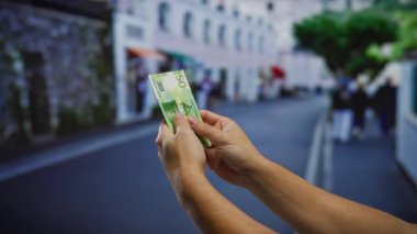 Kentsel bir caddede iş ve yatırım tasvir eden Norveç banknotları tutan bir adam..