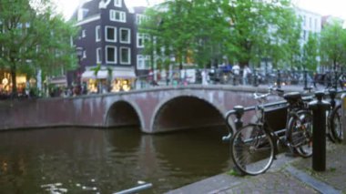 Bisikletli, bulanık arka planlı, mimari sergilenen ve canlı şehir yaşamına sahip amfi kanalların odaklanmış görüntüsü.