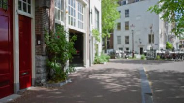 Kırmızı kapılı, bisikletli ve yemyeşil yemyeşil, sakin ve davetkar bir şehir ortamı yaratan Avrupa manzarası..