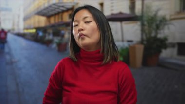 Şehrin arka planında kırmızı süveter giyen bir kadın gençlik cazibesi ve enerjik enerjisiyle şehir dışı yaşam tarzını sergiliyor..