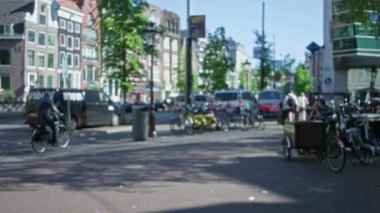 Bulanık şehir manzarasında bulanık bisiklet, sokak ve güneş ışığı altındaki insanlar şehir hayatını ve tipik Alman mimarisini vurguluyor..