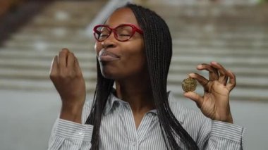 Şehir sokaklarında şifreli para tutan kadın sanal para hakkında heyecanını dile getiriyor.