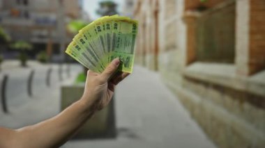 Bir şehir caddesinde el ele tutuşan bangladeşli banknotlar, açık hava ortamında finans ve ekonomi kavramını gösteriyor.