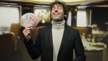 Restoranda gülümseyerek Tayland banknotlarını tutan adam Tayland 'da gelişigüzel iş başarısı kavramını yakalıyor.