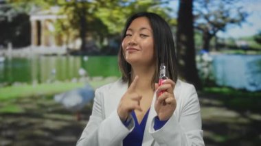 Aydınlık bir günde, bir parkta elinde bir ekoseti tutarken iyi el kol hareketi yapan bir kadın boş vaktini açık havada geçirir ve kültürü kendine güvenle buharlaştırır..