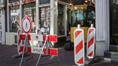 Kalabalık bir kentsel alanda çözünmüş bariyerler ve makinelerle bulanık bir inşaat sahası, şehir ortamında bir bokeh etkisi yaratıyor.