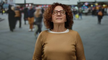 Farklı yayaların dikkat çeken varlıkları arasında sakin bir meditasyon yapan bir kadın..