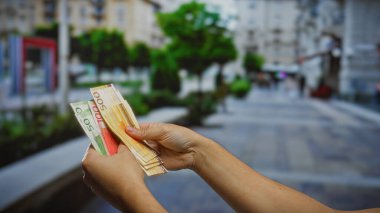 Kentsel bir açık kentte Norveç kronu banknotları tutan kişi sergilenen finansal kavramları ve Norveç 'in para birimine yatırım yapıyor.