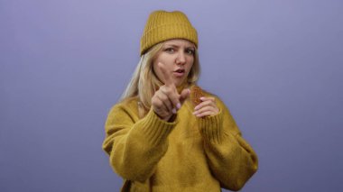 Sarı kazaklı kadın kurabiye jestleri ile hayır mor duvara karşı