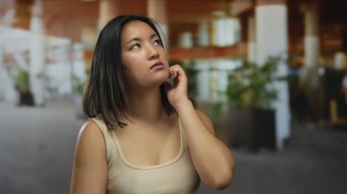 Hareketli bir şehir caddesinde düşünceli bir ifadeye sahip genç kadın şehir hayatı ile çevrili iken derin düşüncelere dalmayı öneriyor..