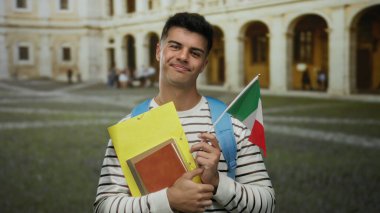 İtalyan öğrenci gülümsüyor, kitaplar ve İtalyan bayrağı tarihi üniversite avlusunda.
