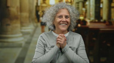 Kilisede gri saçlarıyla gülümseyen bir kadın olgun bilgeliği ve dinginliği temsil eden süslü bir mimarinin ortasında neşeli bir ifade sergiliyor..