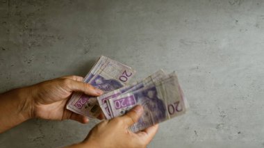 İsveç Krona para birimini somut bir arkaplan karşısında sayan eller, mali işlemleri vurguluyor.