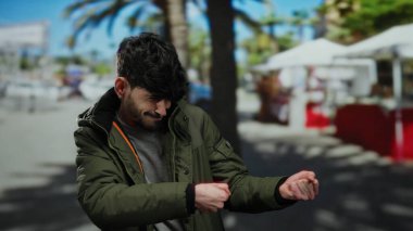 Sokakta hayali bir halatı çeken, ceketli, şehir planlı, neşeli bir şehir anını yakalayan İspanyol genç adam..