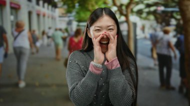 Kalabalık bir şehir sokağında neşeli bir şekilde bağıran kadın canlı şehir yaşamını ve çeşitli yayaları güneşli bir günde harekete geçiriyor..
