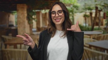 Gülümseyen kadın şehir merkezindeki restoran terasına işaret ederken beni ara..