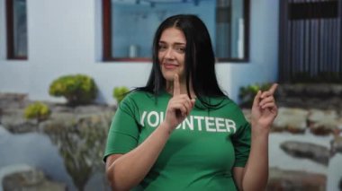 Ayrıca yeşil gönüllü gömlekli kadın şehir caddesinde dikiliyor. Yüzünde bitkiler ve şehir manzarasıyla yukarı doğru gülümsüyor..