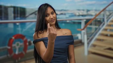 El kol hareketi yapan bir kadın geldi. Gezgin gemisinde. Açık deniz manzarasını ve gökyüzünü canlı gündüz atmosferiyle Latin usulü yakalıyor.