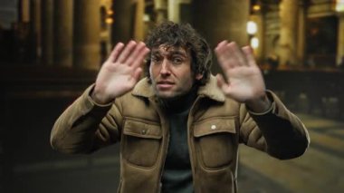 İçerideki genç adam kahverengi ceketli ve elleri güzel aydınlatılmış bir kilisede kaldırılmış, ilginç ve gizemli bir ifade sergiliyor..