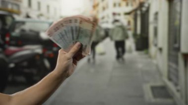 Şehir caddesinde, bulanık bir adamla el ele tutuşan Bangladeşli Taka şehir merkezinde geziyor, açık havada para alışverişi yapıyor..