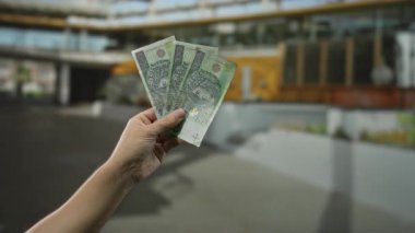 Şehir sokaklarında elinde Polonya parası tutan adam para, finans ve şehir yaşam tarzı kavramını gözler önüne seriyor..