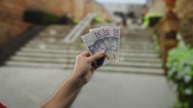İsveç Krona 'nın el ele tutuştuğu açık bir şehir caddesinde şehir ekonomisi kavramını yakalayan banknotlar..