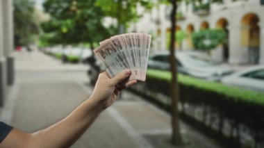 Bangladeş banknotlarını şehir sokaklarında elinde tutan adam, şehir ortamını ve döviz kurunu gözler önüne seriyor..