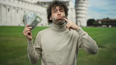 Bangladeshi Taka 'yı dışarıda tutan adam İtalya' daki sidik kulesinin yanında, şehir sokaklarında neşeli bir ifadeyle para gösteriyor..