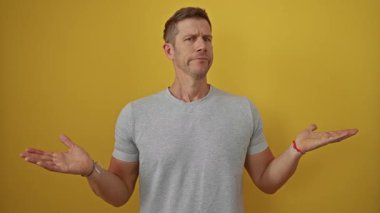 Sarı arka planda ifadelerle poz veren genç bir adam modern bir portrede kendine güvenen bir tavır ve rahat bir tarz sergiliyor..