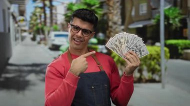 Kalabalık bir caddede Amerikan dolarlarını elinde tutan adam güvenle gülümsüyor..