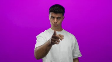 Beyaz gömlekli genç adam canlı pembe arka planda jest yapıyor. Duygularını ve tutumunu gösteriyor. Çeşitliliği ve modern tarzı gösteriyor.