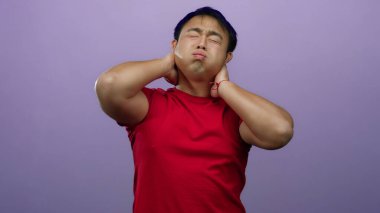 Mor arka planda kırmızı gömlekli adam muhtemelen boyun ağrısından ya da gözleri kapalı ve elleri boyunda gerilimden rahatsız olur..