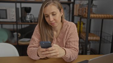 Ofisteki kadın rahat bir ifadeyle masa başında oturmuş modern mobilyalarla çevrili rahat bir şekilde verimli bir çalışma ortamı öneriyor..