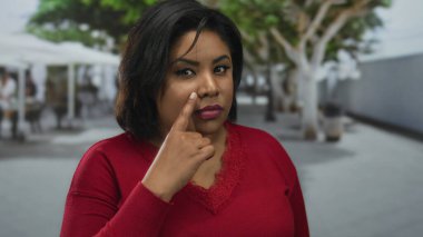 Kırmızı noktalı kadın, şehir dışında sokak ortamında parmakları olan bulanık ağaçlar ve arka plan renklendirme ifadeleri ve odak noktası olan kırmızı noktalı kadın.