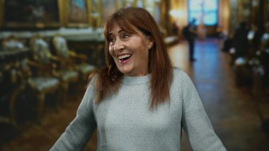 Müze ortamında zarif bir dekorla gülümseyen bir kadın kültürel ortamda neşeli bir anı yakalıyor ve İspanyol mirasını ön plana çıkarıyor..