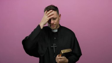 Pembe arka planda İncil 'i tutan ve alnına dokunan bir rahip.