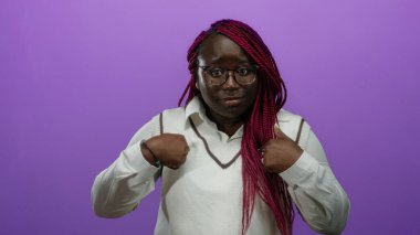Örgülü bir kadın, kendini mor bir arkaplan üzerinde belirterek etkileyici jestler ve gözlüklerle, şaşkınlık ve merakını dile getiriyor..