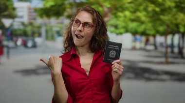Bir İtalyan pasaportu taşıyan bir kadın heyecanlı bir şekilde şehir sokaklarında gündüz vakti onu işaret ediyor..