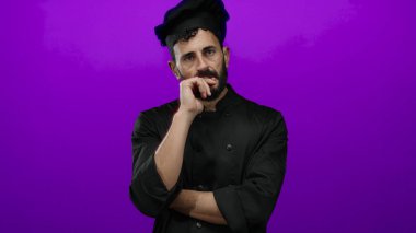 Sakallı İspanyol aşçı parlak mor arka plana karşı düşünceli poz verdi..