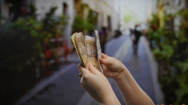 Peru tabanını elinde tutan kadının elleri şehir caddesinde açık havada bir ticaret sahnesi yaratıyor..