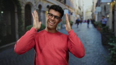 Şehrin caddesinde kendine güvenen genç bir adam gözlük takıyor ve kırmızı bir süveter giyiyor. Geçmişi bulanık, büyüleyici ve arkadaş canlısı..
